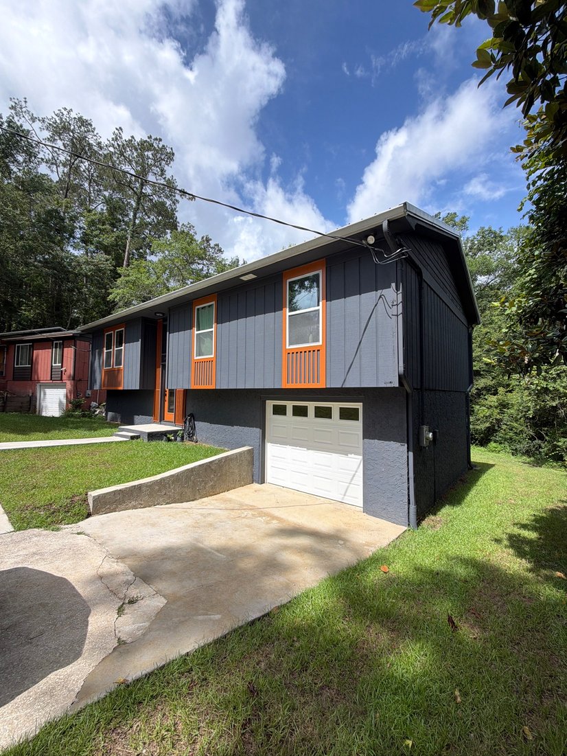 Charcoal home with orange trim accents and white seamless gutters