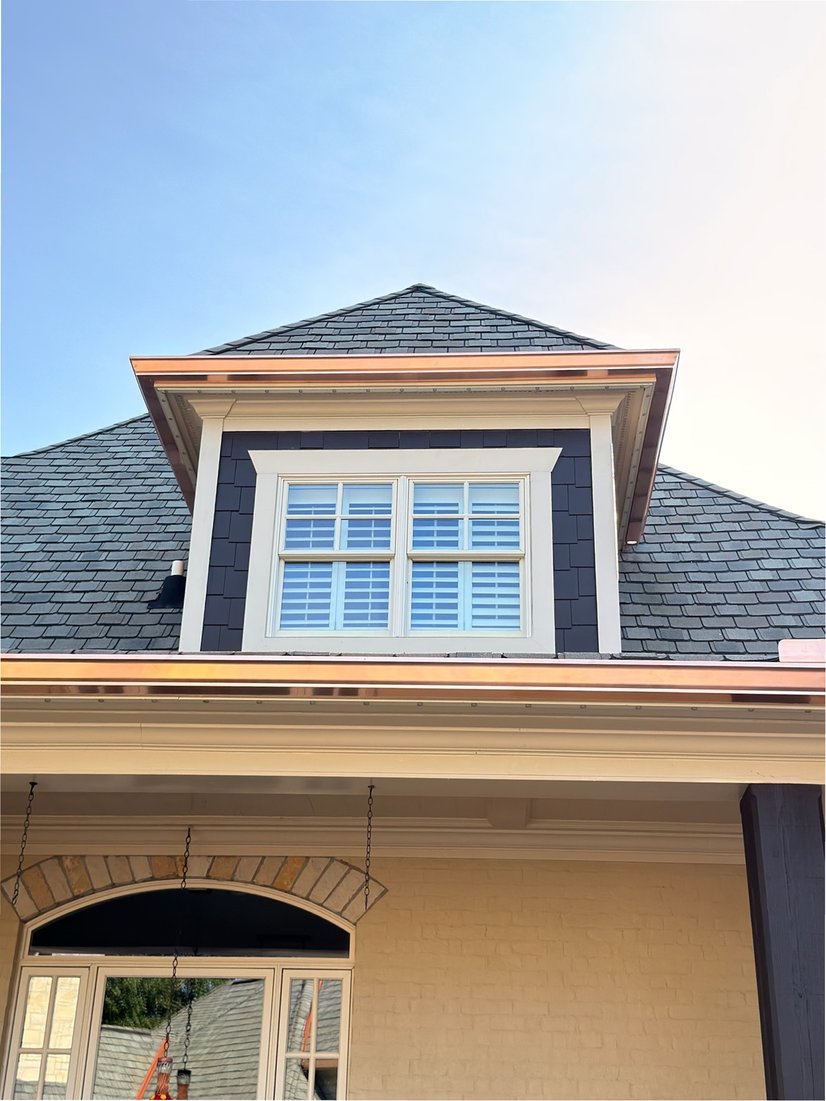 Close-up of copper seamless gutters on a dormer and roofline