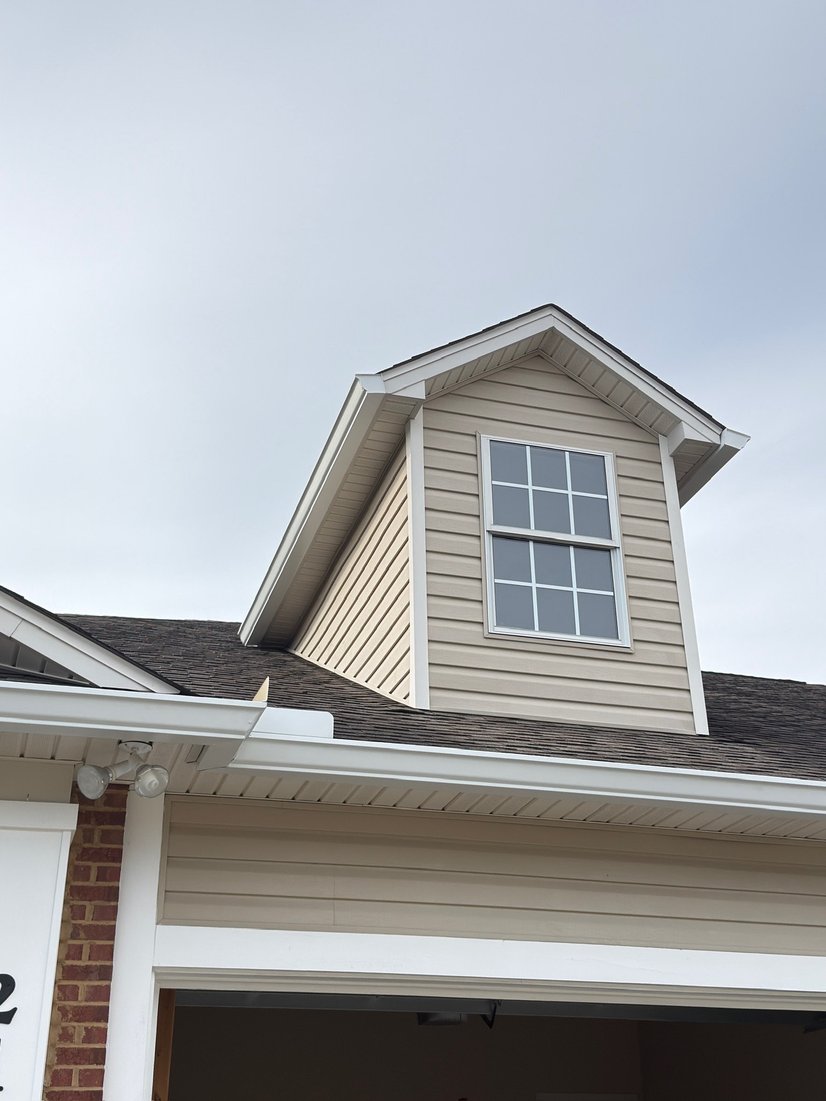 Roof dormer with seamless gutters and a downspout