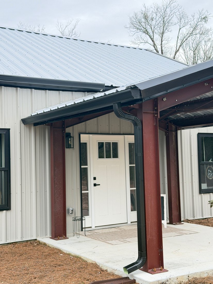 Metal-roof home entrance with seamless gutters